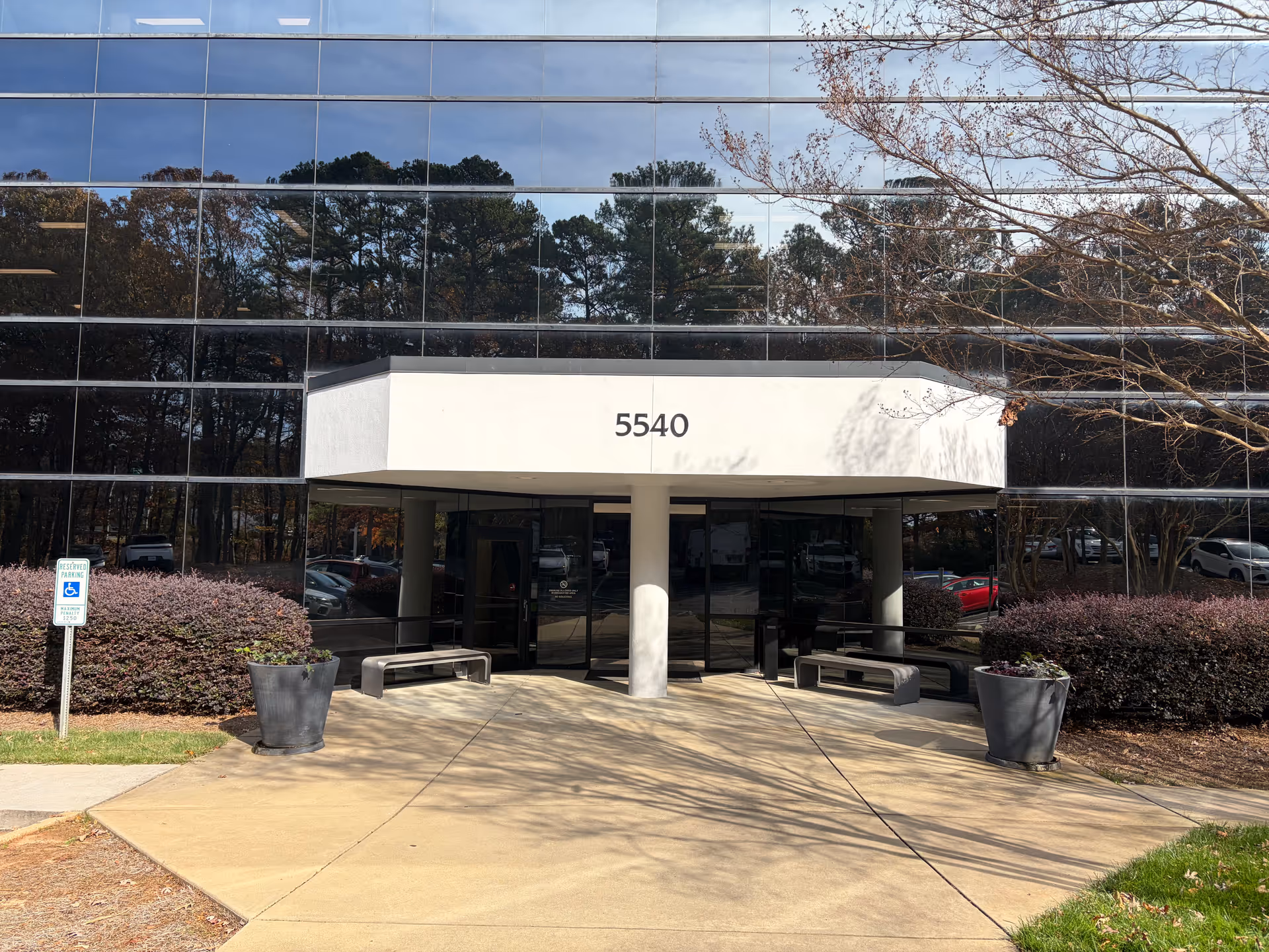 Glass-front building entrance with a white canopy and address 5540, no people present.