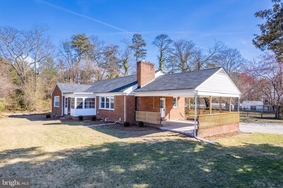 Single-story brick assisted living facility with a wide covered front porch and surrounding lawn.