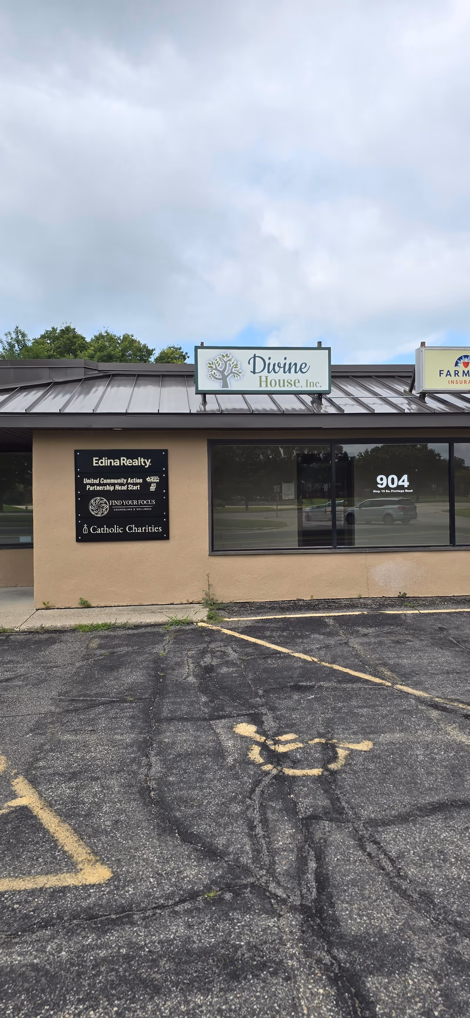 A single-story commercial building with Divine House, Inc. sign and parking lot in front.