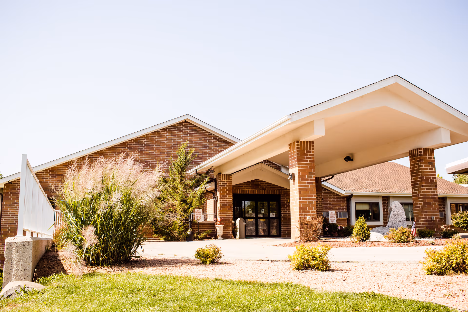 Front view of a brick senior living facility with a covered entrance