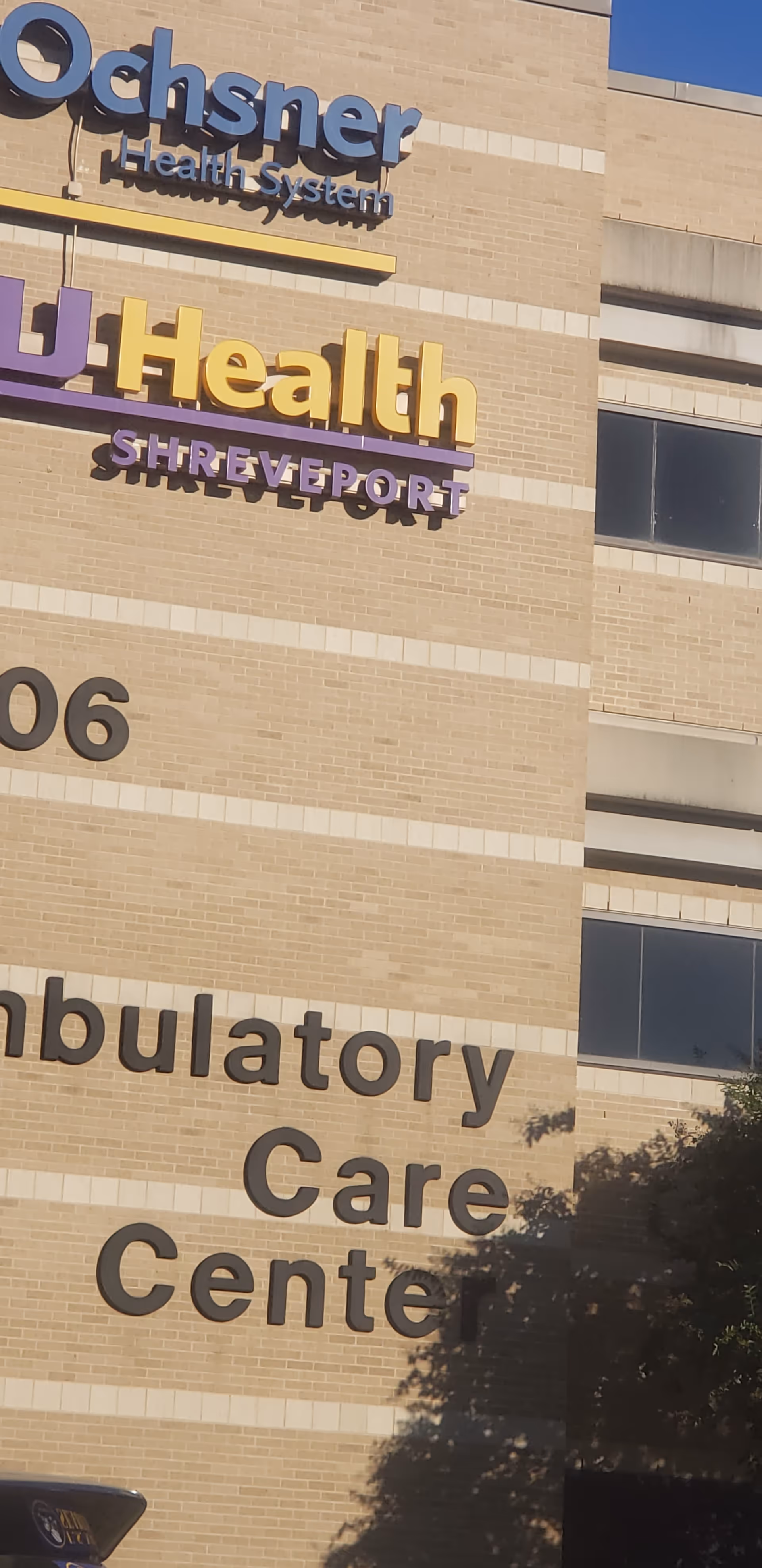 Exterior view of Ochsner LSU Health Ambulatory Care Center sign on brick building.