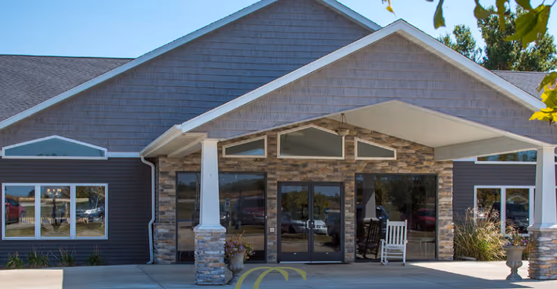 Front entrance of High Point Residence Taylorville with stone pillars and glass doors.