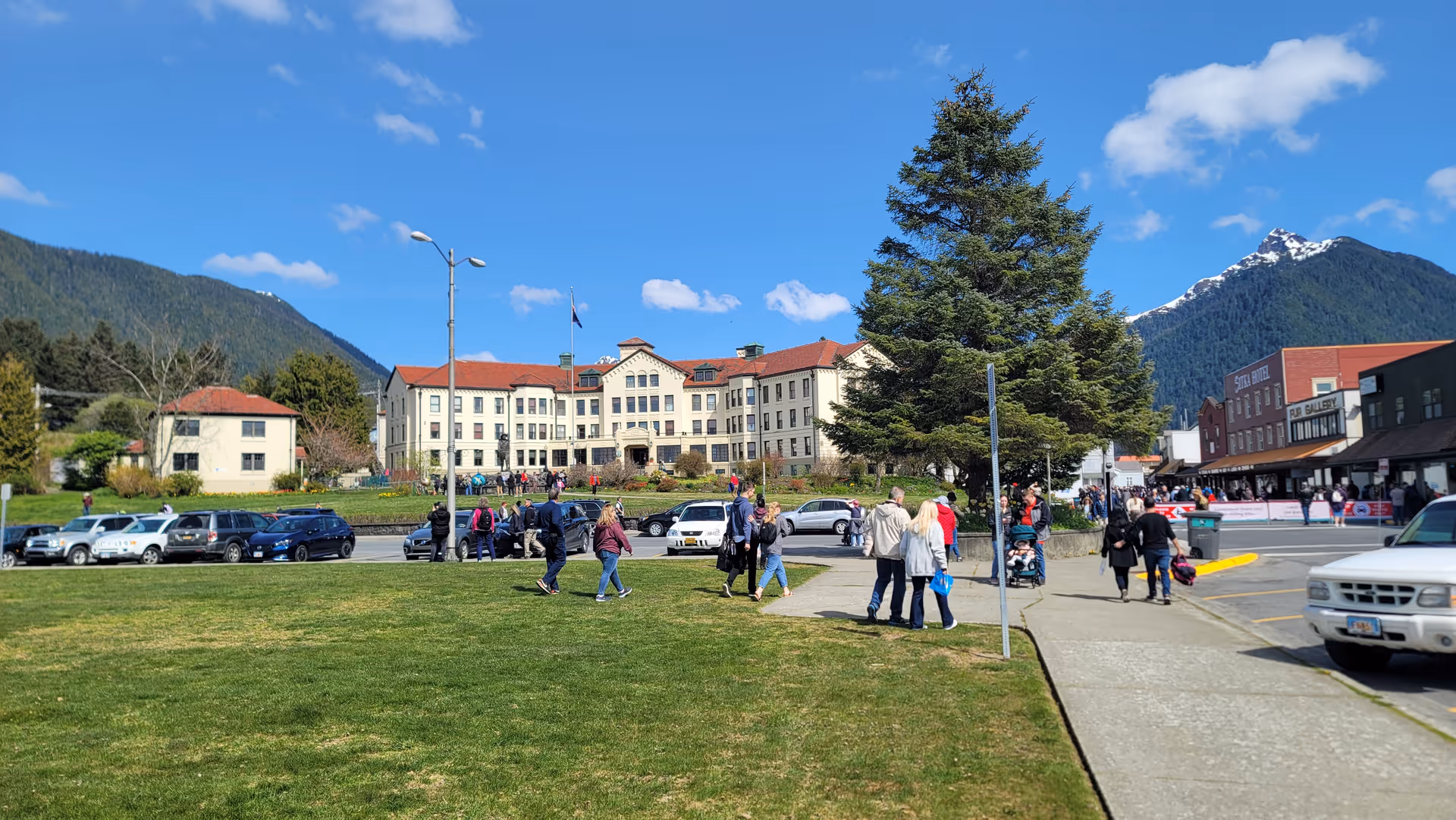 Exterior view of Pioneers' Home Sitka with people walking on the lawn in front.