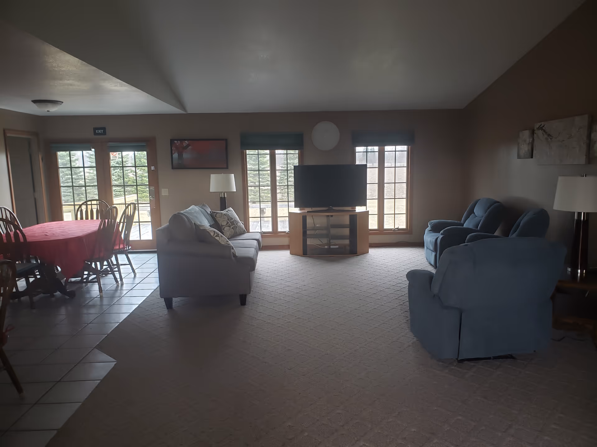 Cozy senior living common area with couches, a TV, and large windows.
