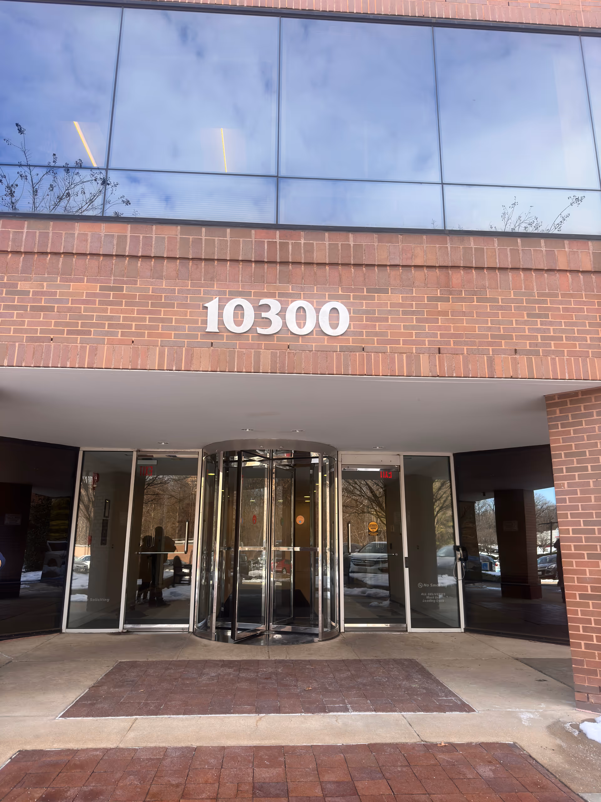 Brick building entrance with a revolving door and the number 10300.