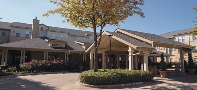 Exterior view of Town Village Crossing with a covered entrance and landscaped circular drive.