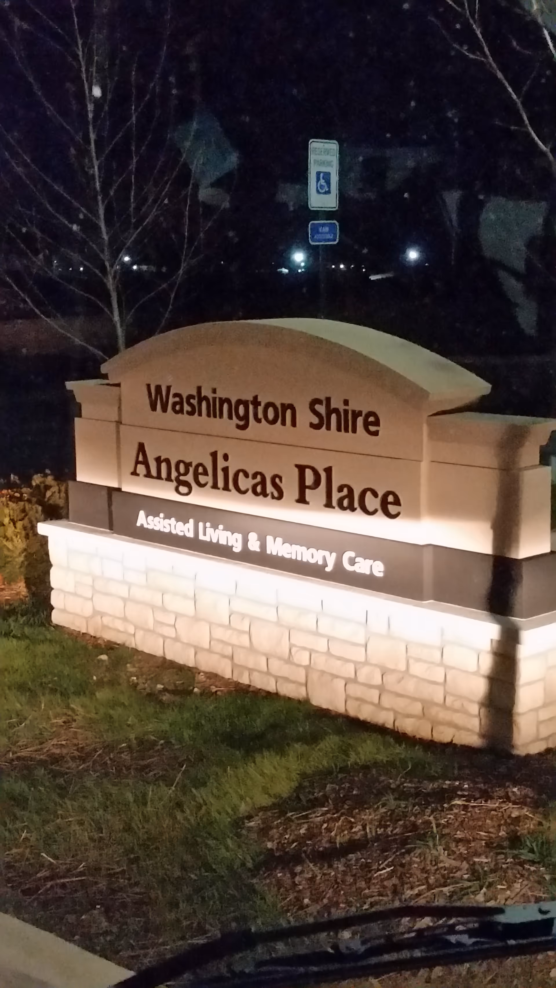 Nighttime view of a lit sign for Washington Shire Angelicas Place, Assisted Living and Memory Care.