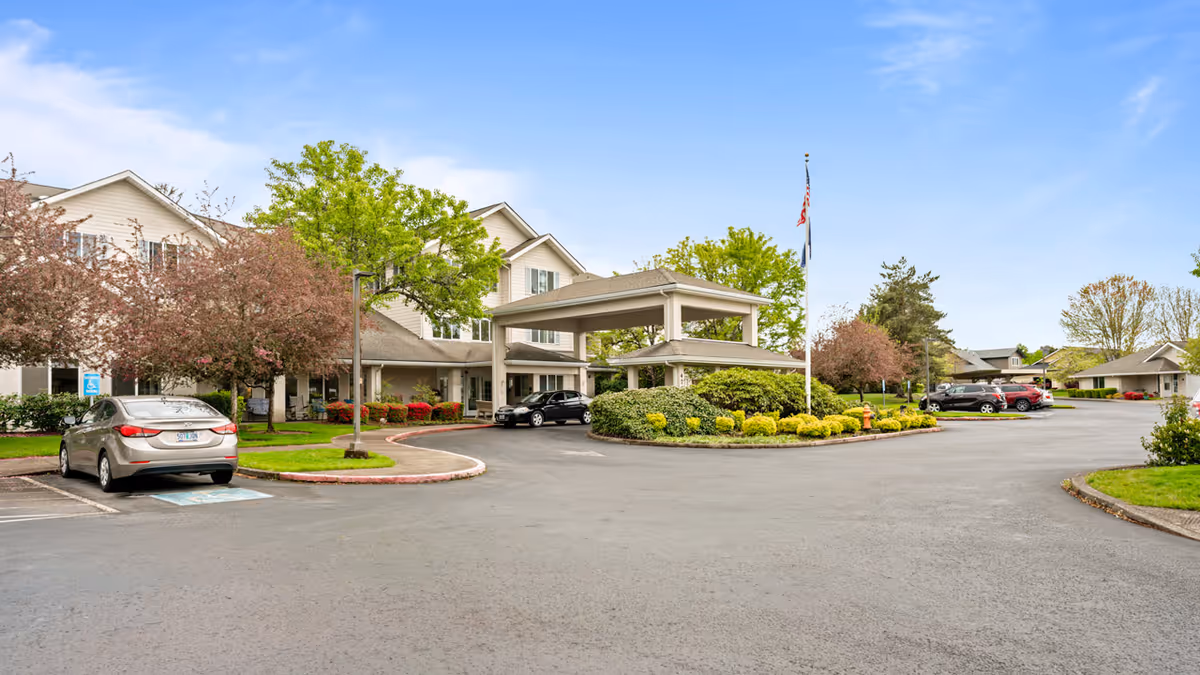 Exterior view of Stoneybrook Lodge front with covered entry, parking, and landscaped circle.