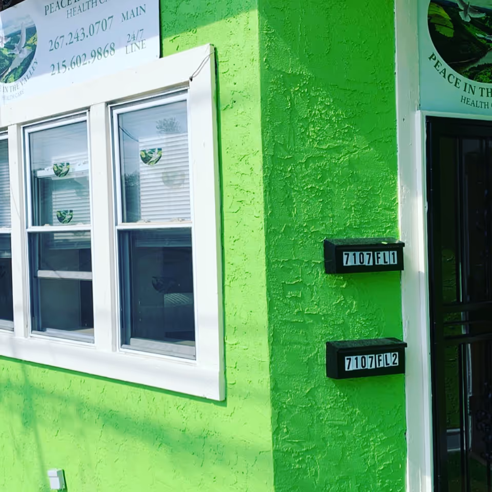 Bright green exterior of a senior care facility with windows and address boxes.
