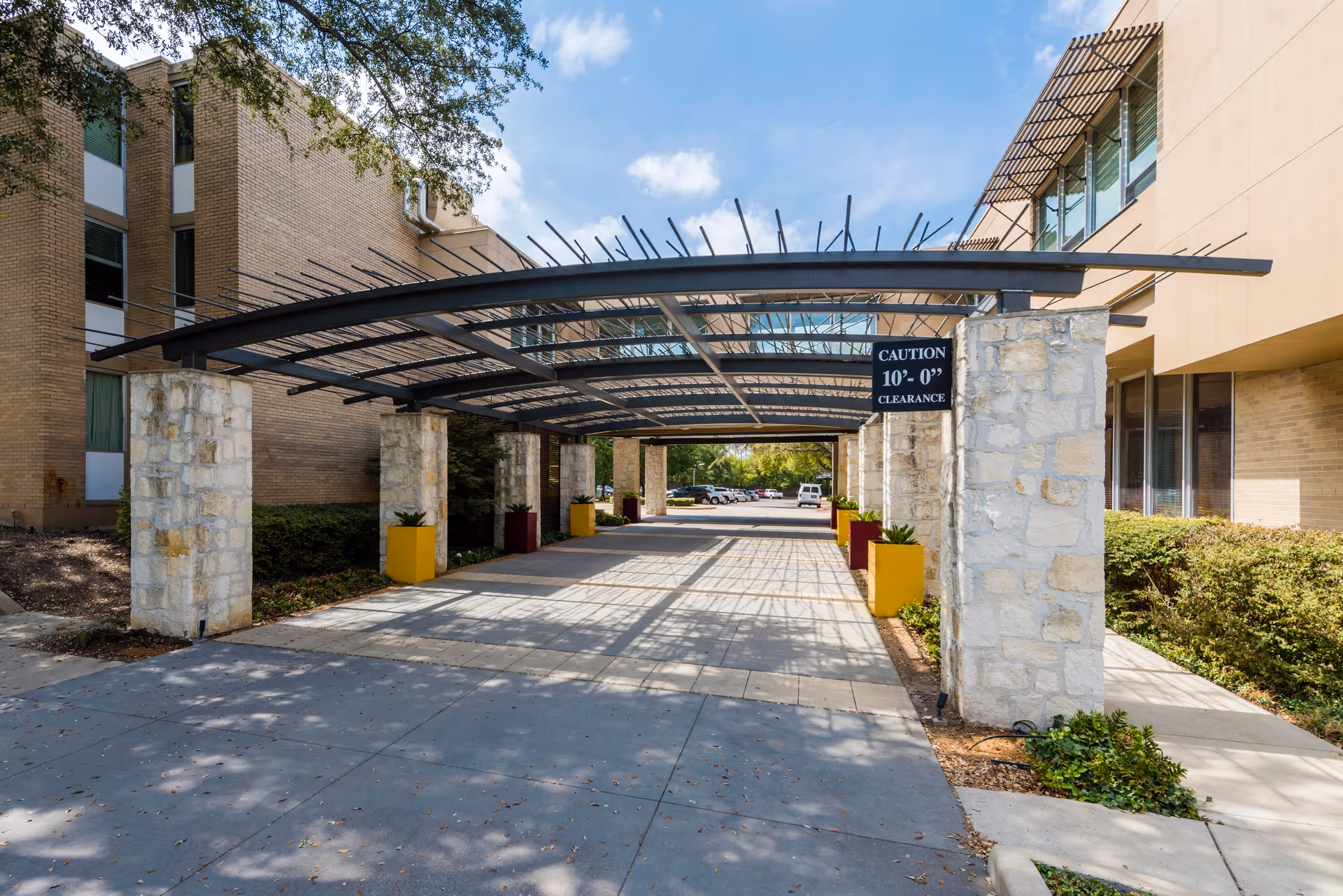 Exterior view of Autumn Leaves facility with a covered driveway and stone pillars.