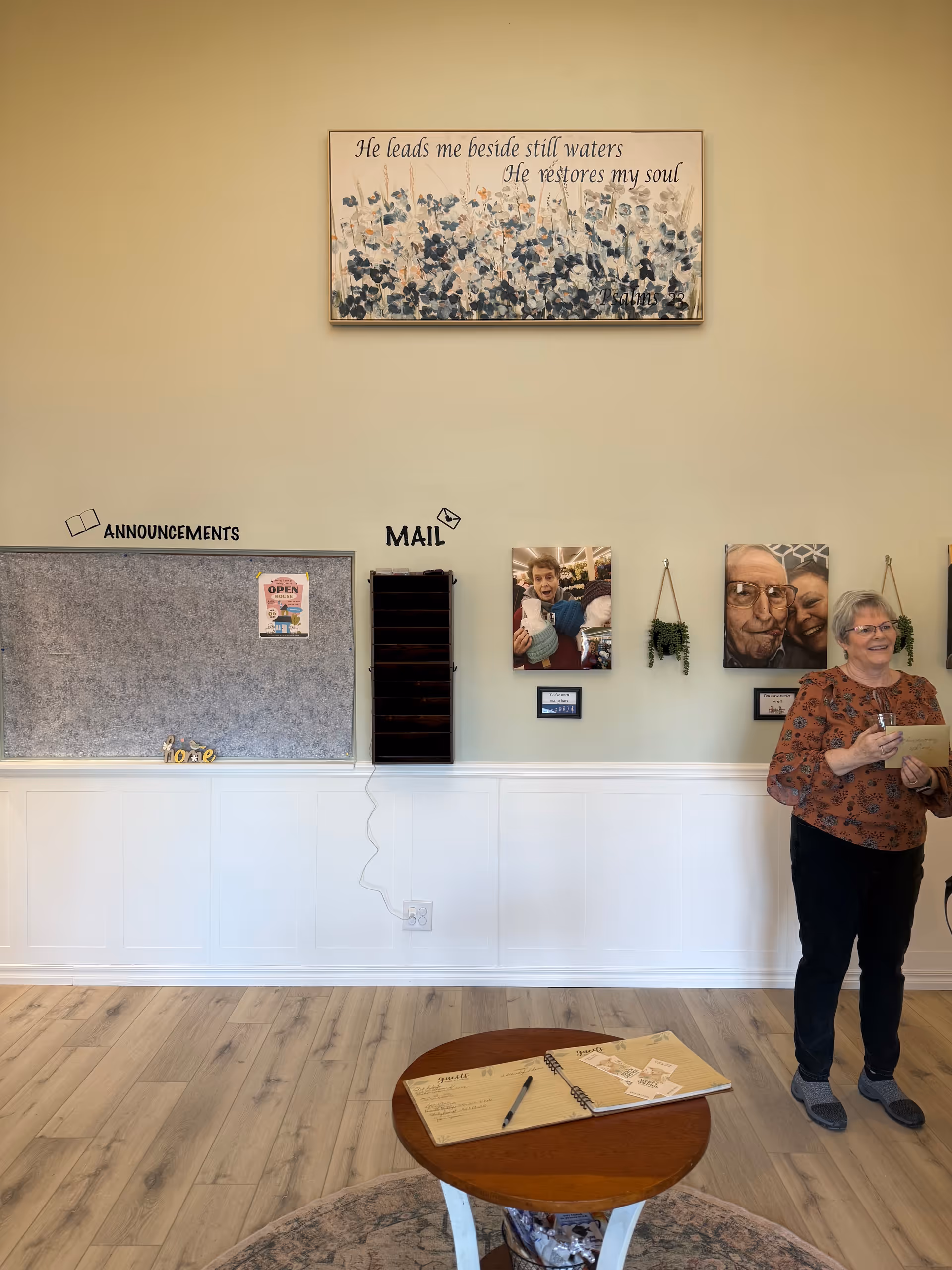 Senior living lobby with staff member near mail slots and announcements.