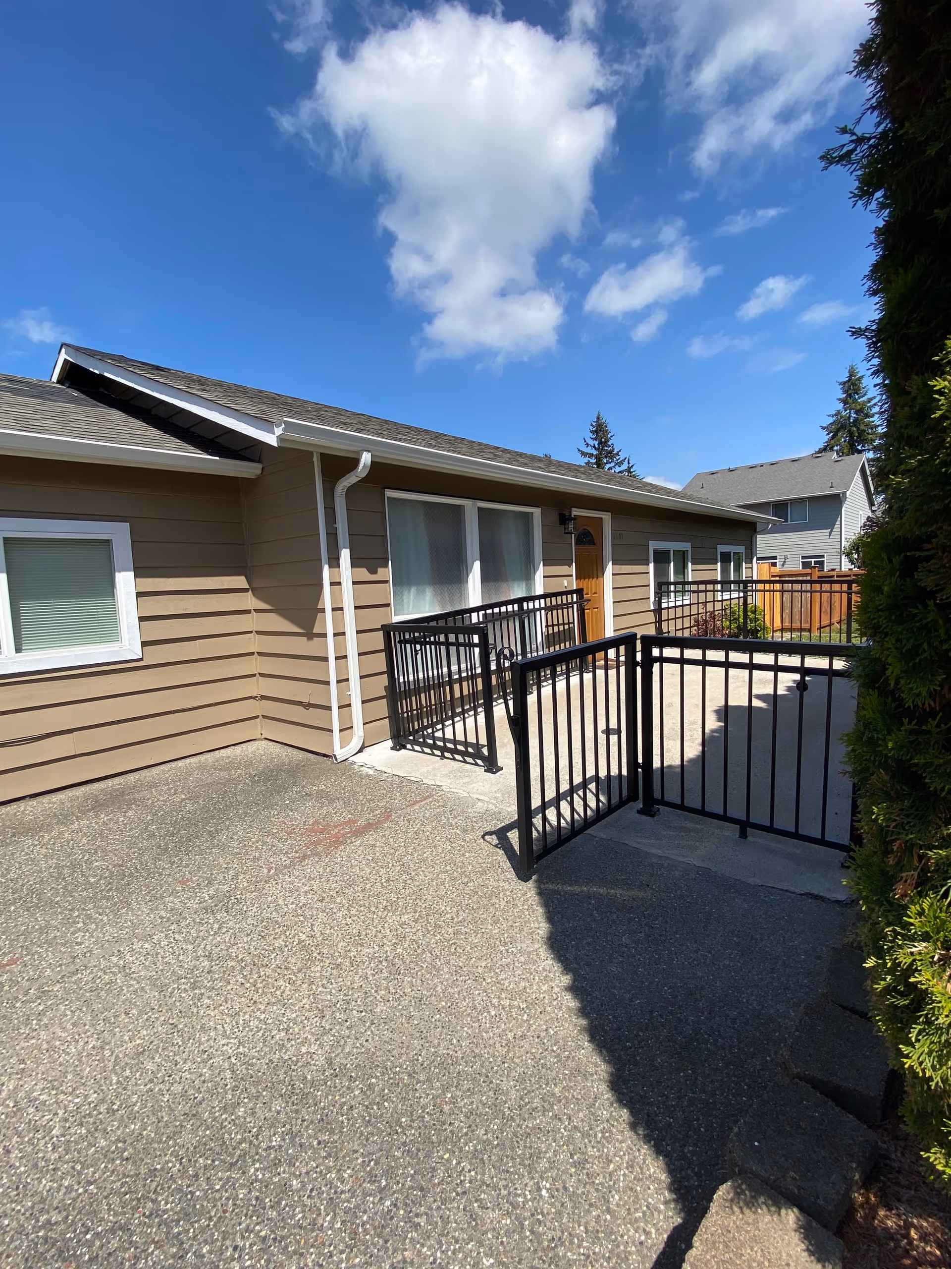 Exterior view of a Destined Care Adult Family Home with a ramp and black railing.