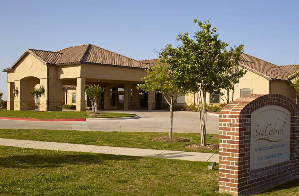 Exterior view of San Gabriel Rehabilitation and Care Center with brick entry sign.