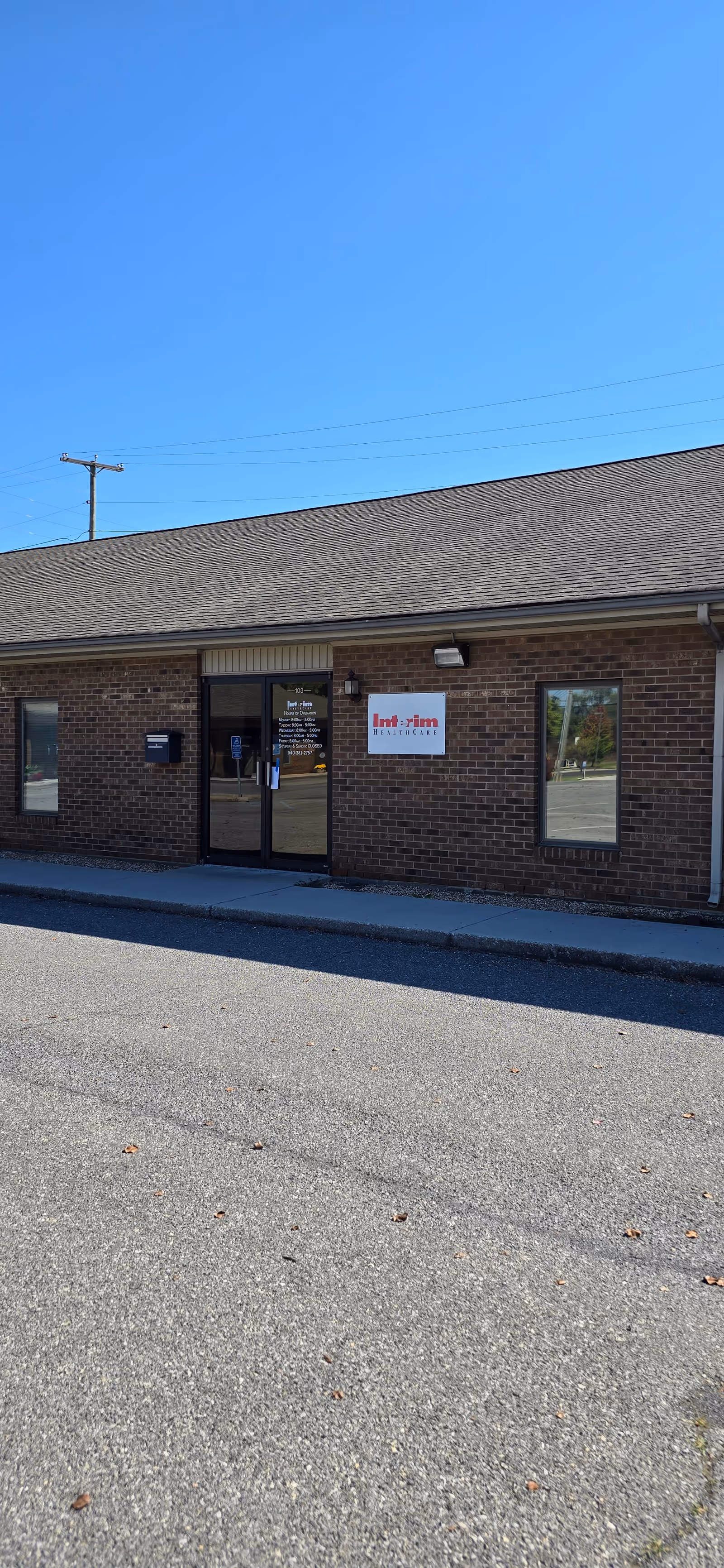 Brick facility exterior with glass doors and an Interim HealthCare sign.