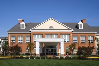 Front view of a brick senior living facility with a central entrance.