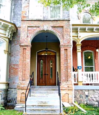 Brick building entrance with arched doorway and wooden double doors.