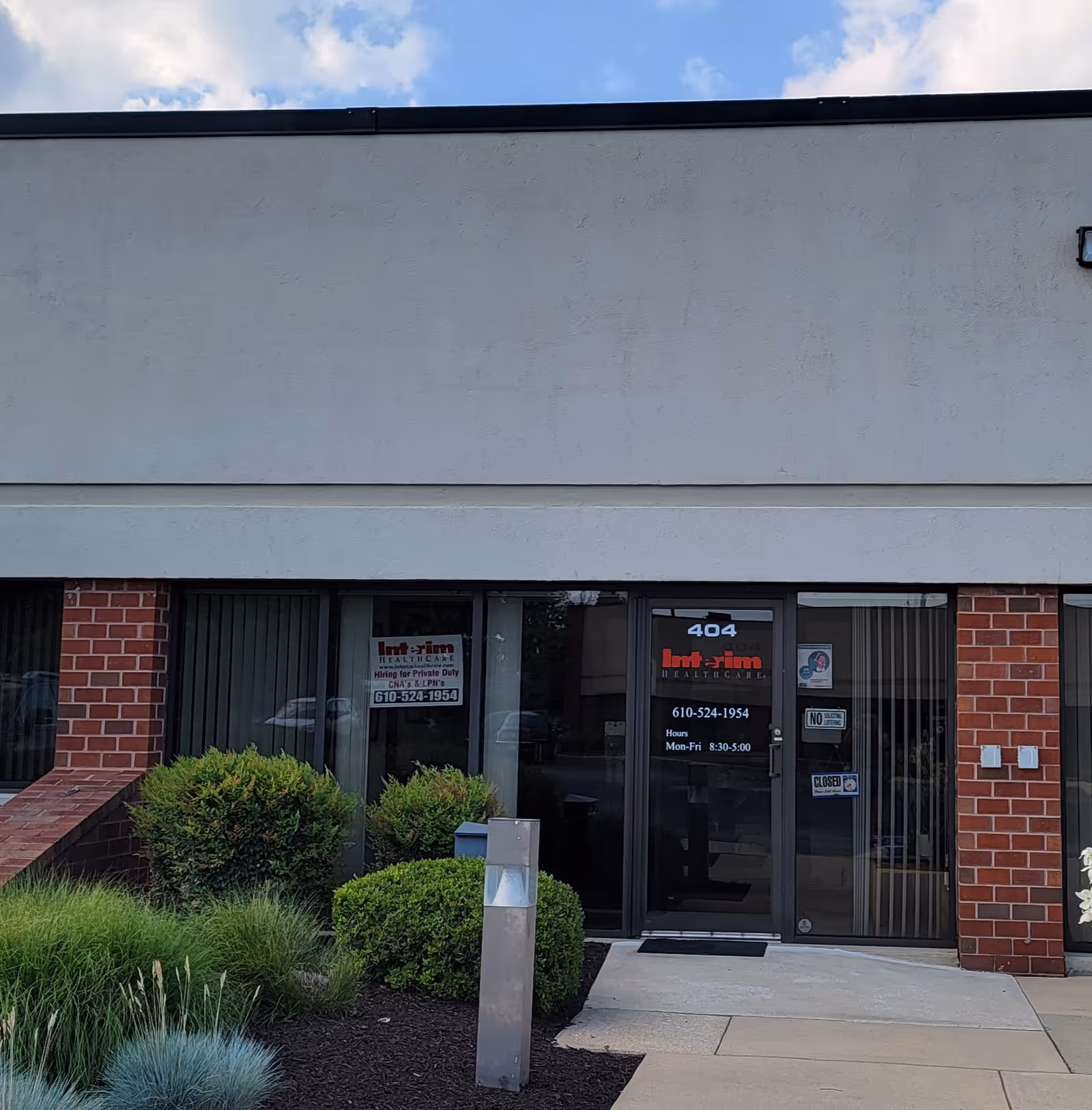 Front entrance of Interim HealthCare office with glass doors and landscaping.