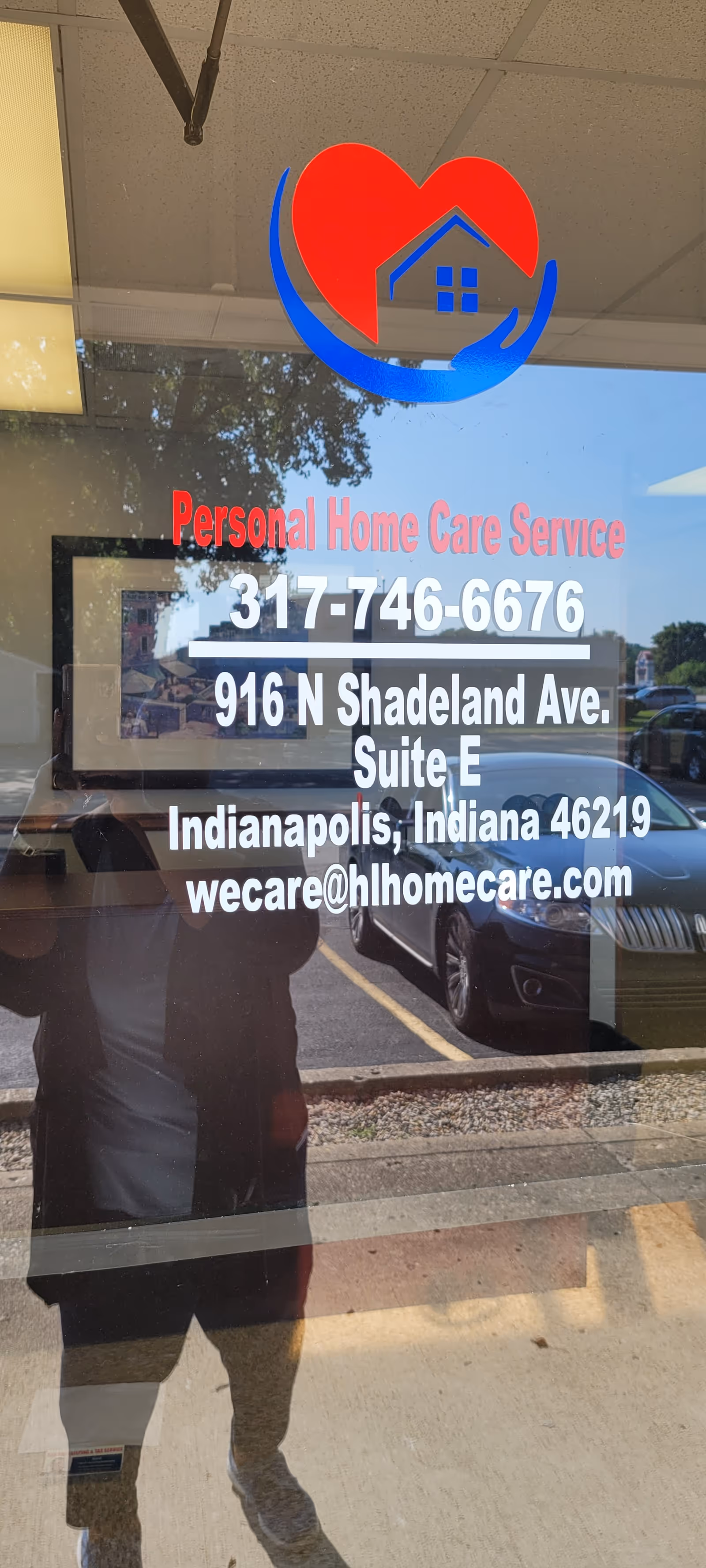 Glass storefront door with heart-house logo and contact details for Personal Home Care Service