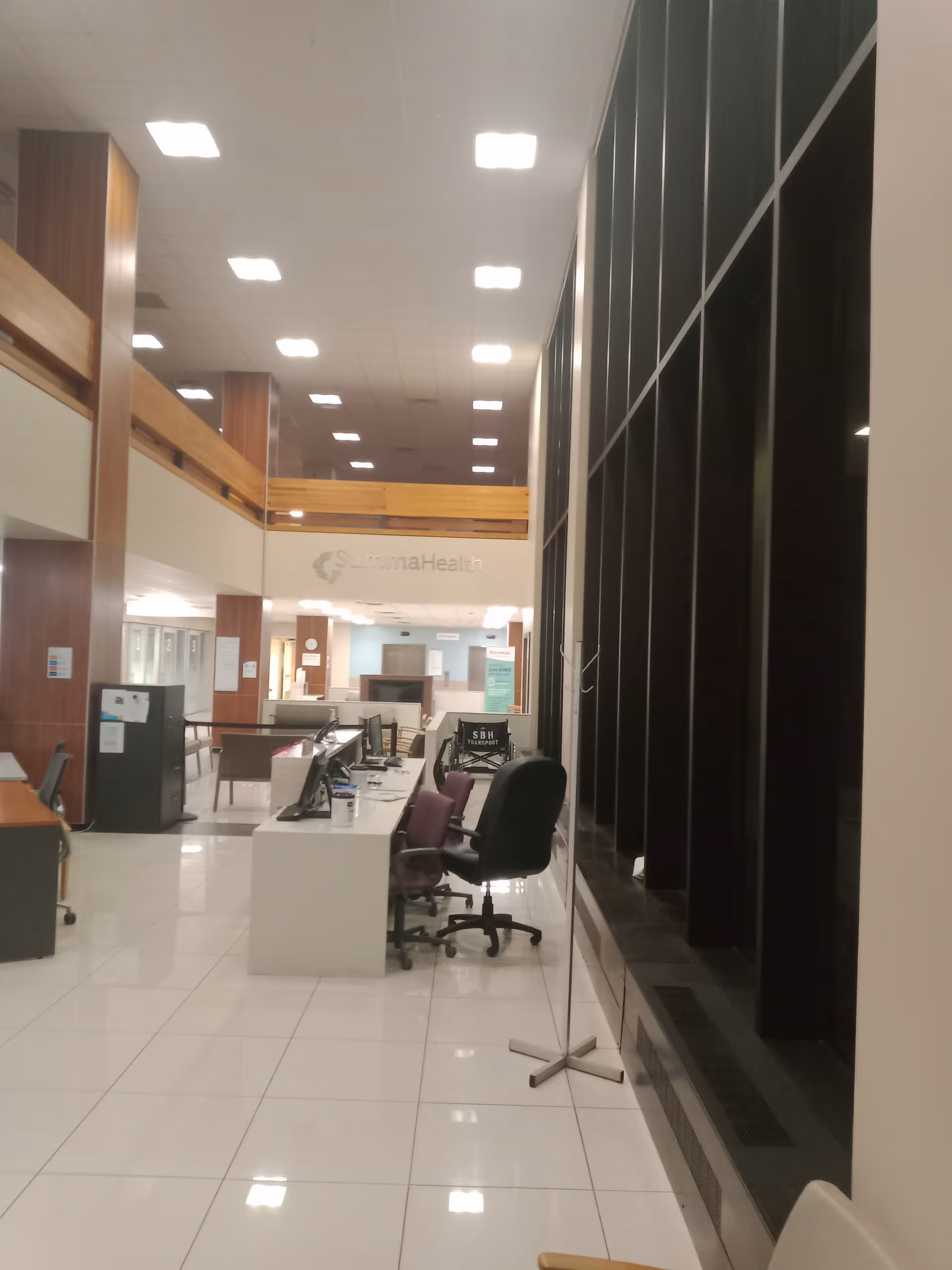 Bright interior lobby with workstations, chairs, and a reception desk.