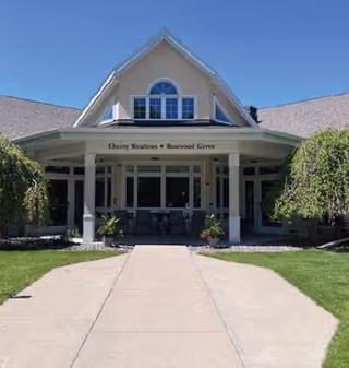 Front exterior of Cherry Meadows Hospice building with a covered entrance and landscaping.