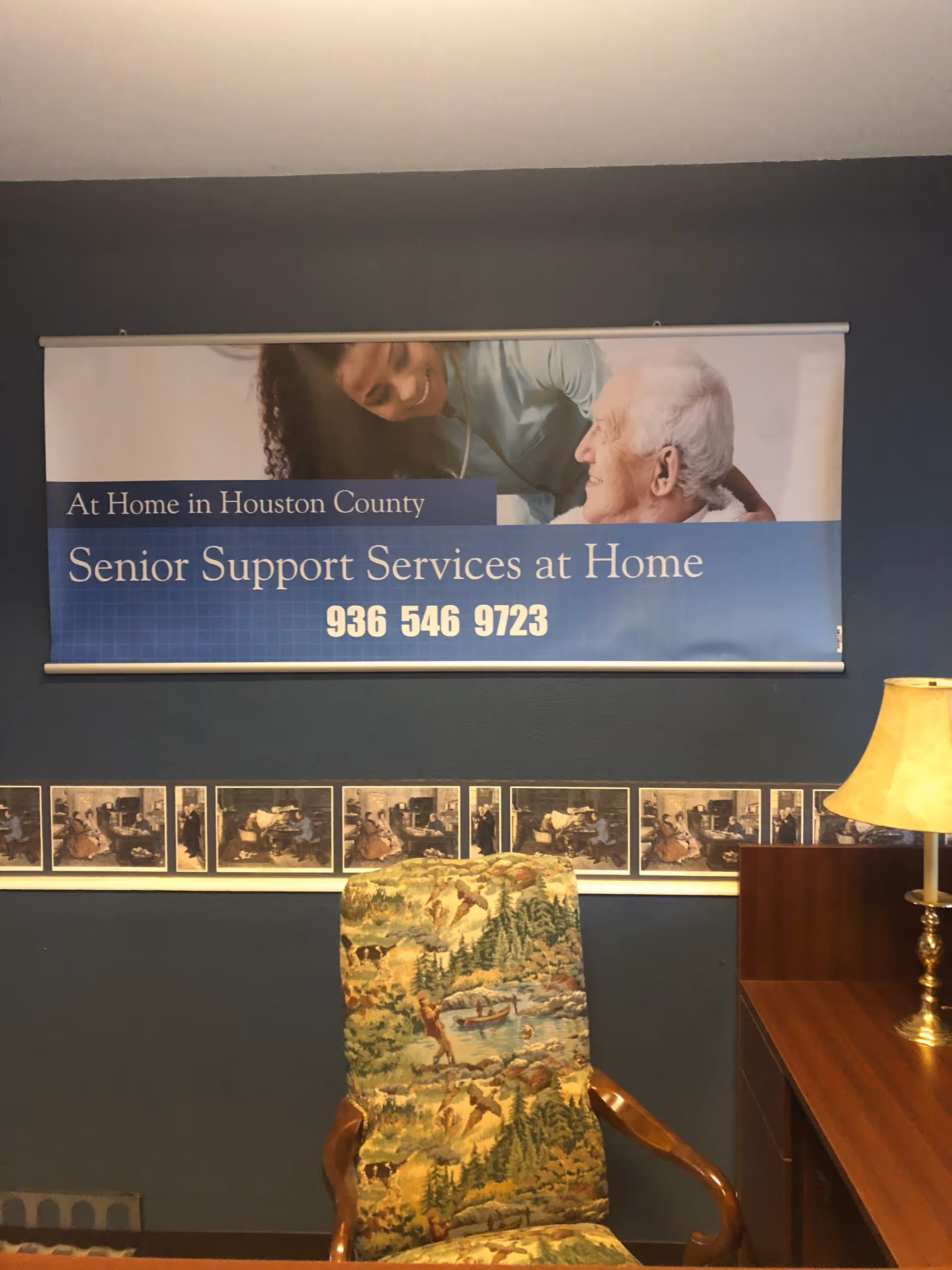 Indoor lobby area with a banner reading Senior Support Services at Home and a floral chair.