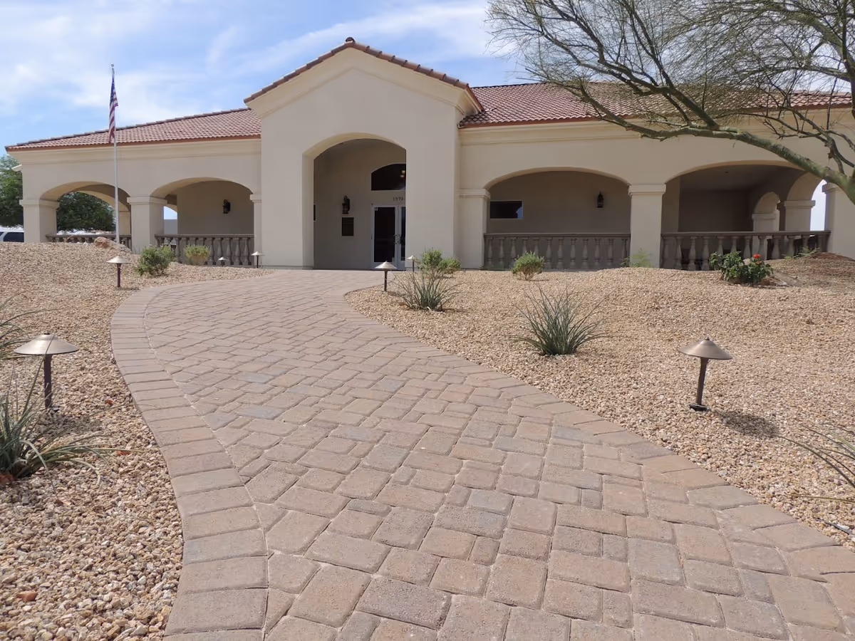 Exterior view of Lake House Assisted Living with a curved walkway and arches.