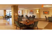 Interior dining area with tables and chairs inside a senior living facility.
