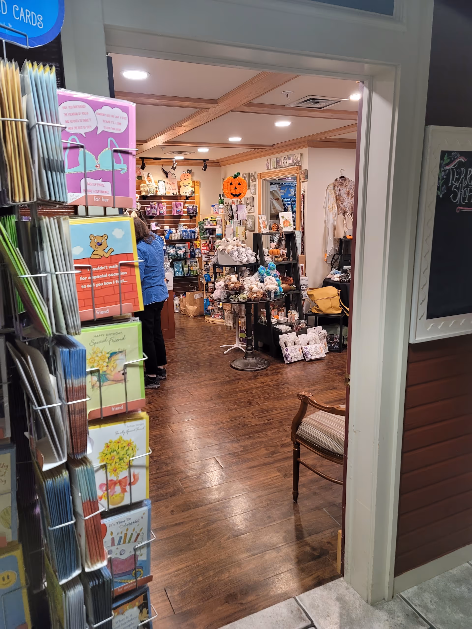 Wide view of a gift shop inside a senior living facility with wooden floors and displays.