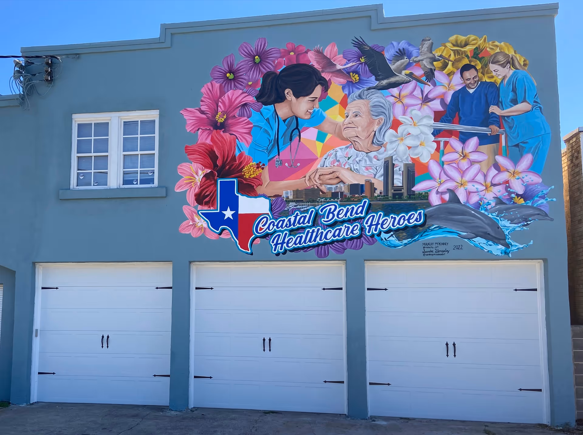 Exterior wall mural featuring nurses, a senior patient, and a Texas-shaped emblem.