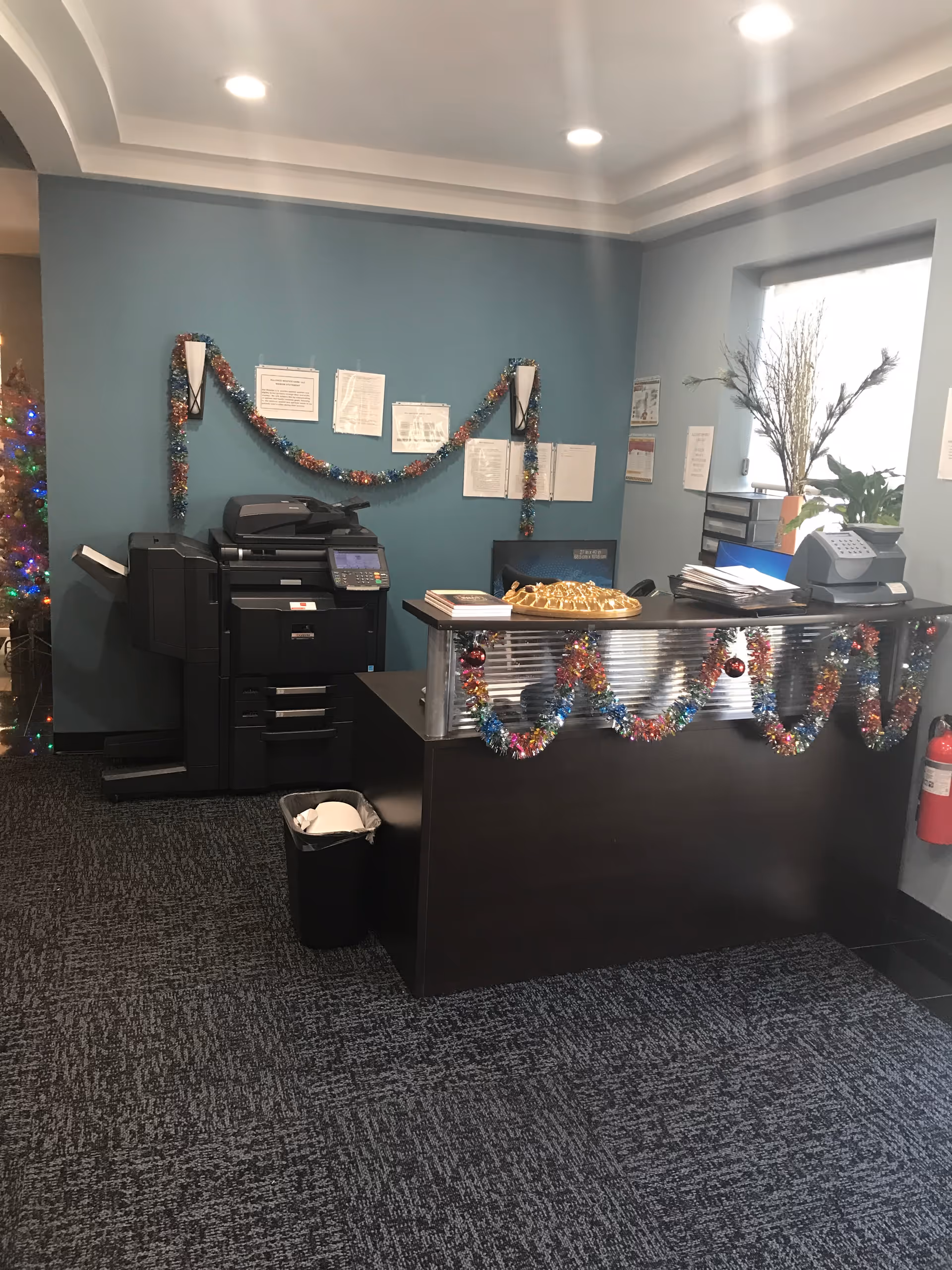 Reception desk in a decorated interior lobby of a senior care facility with garlands.
