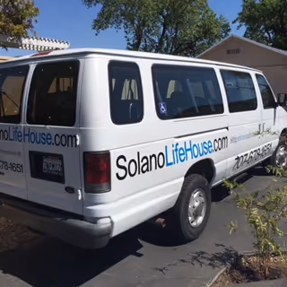 White Solano Life House van parked in a lot beside a building