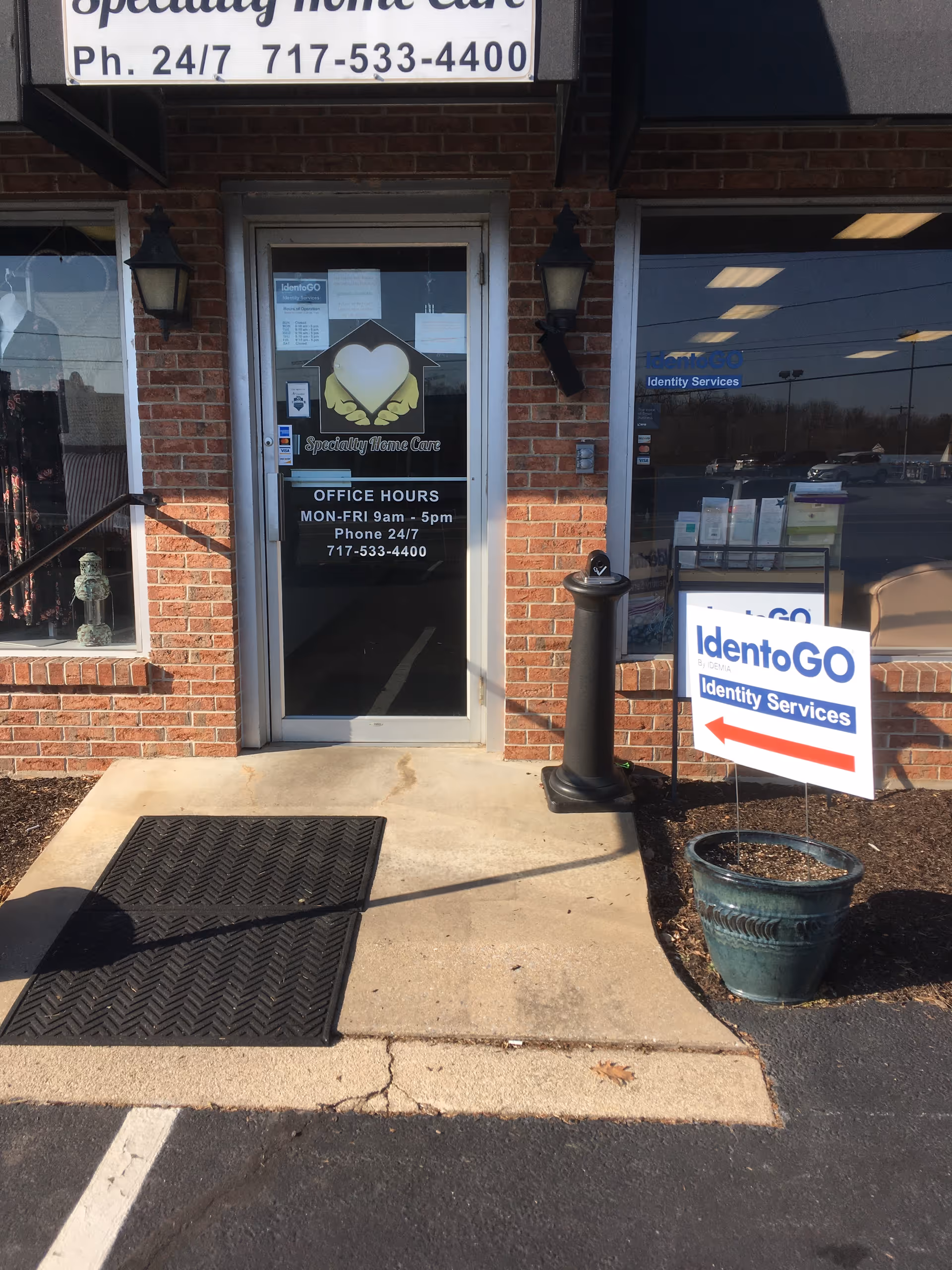 Brick storefront with glass door labeled Specialty Home Care and posted office hours.