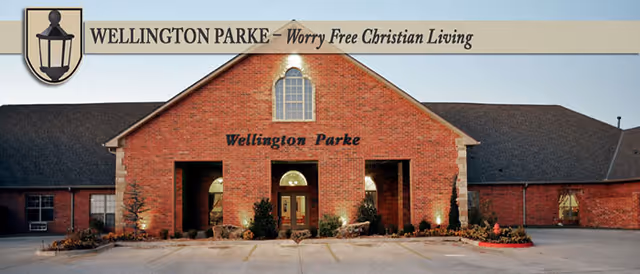 Brick building entrance with Wellington Parke signage and a decorative lantern emblem.