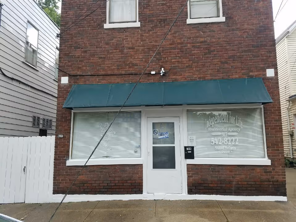 Brick storefront with a green awning and glass door labeled Independent For Life
