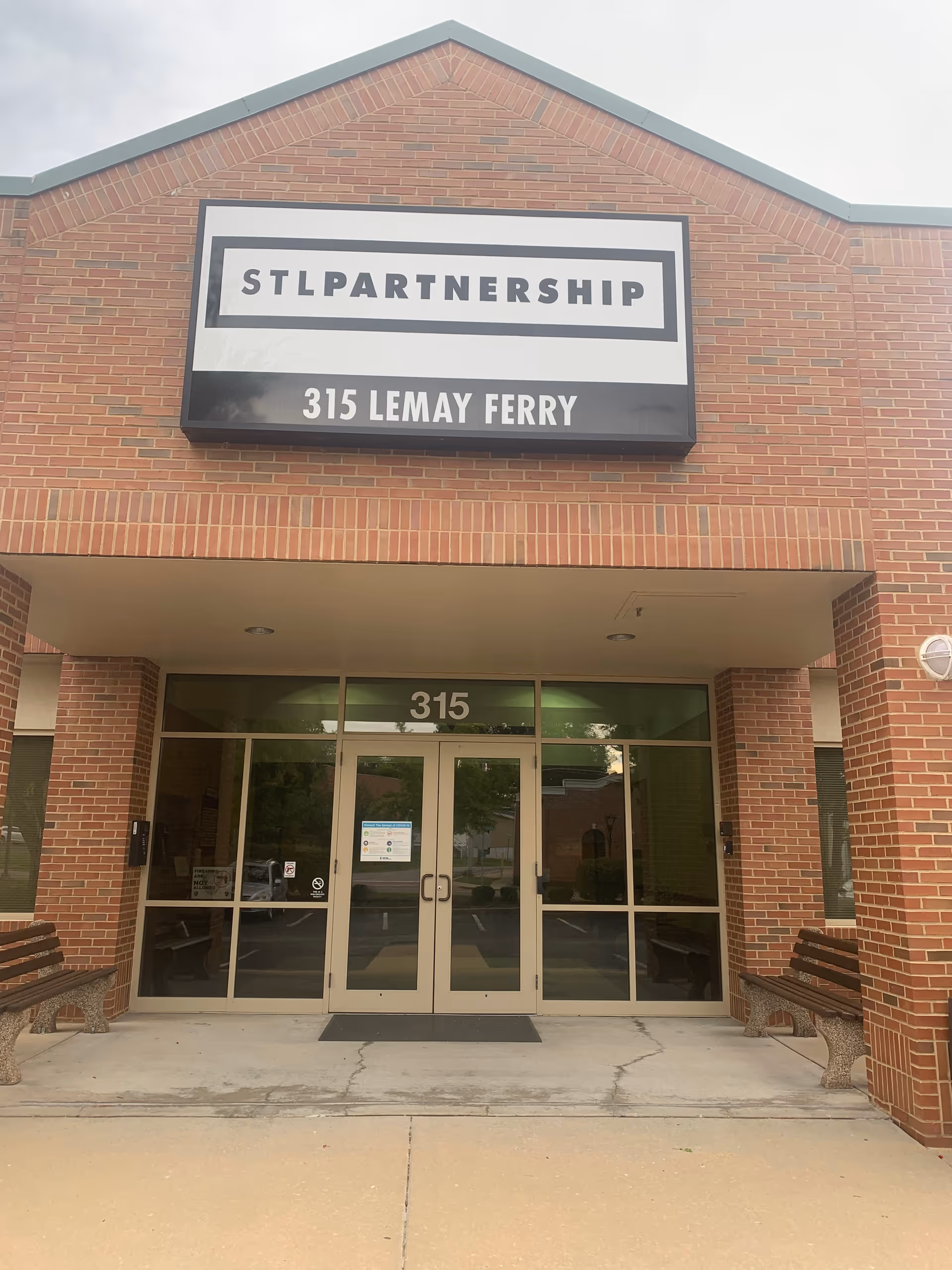 Brick building entrance with large STL Partnership sign and glass doors.