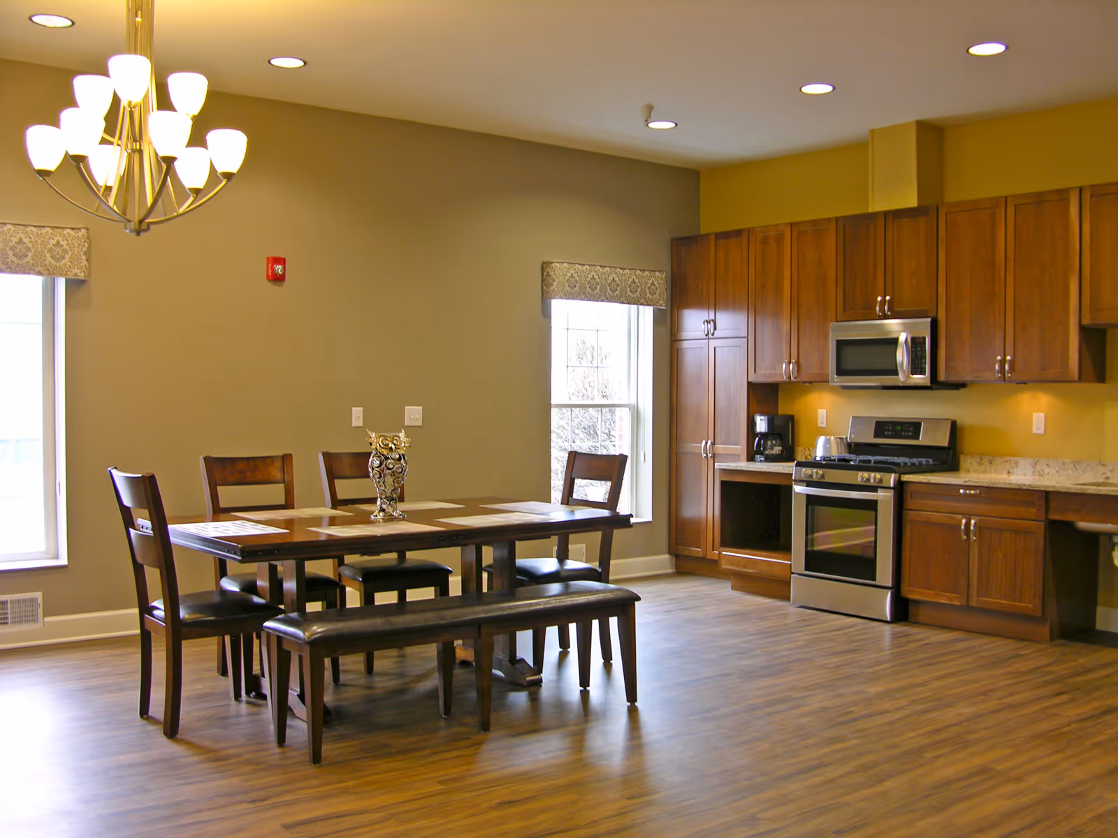 Spacious dining area with a wooden table, bench seating, and a modern kitchen in the background.