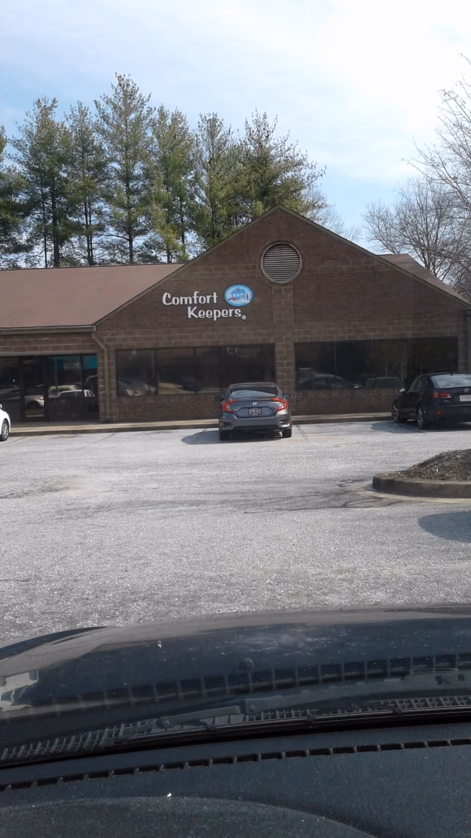 Exterior view of Comfort Keepers Home Care building with parked cars in front.