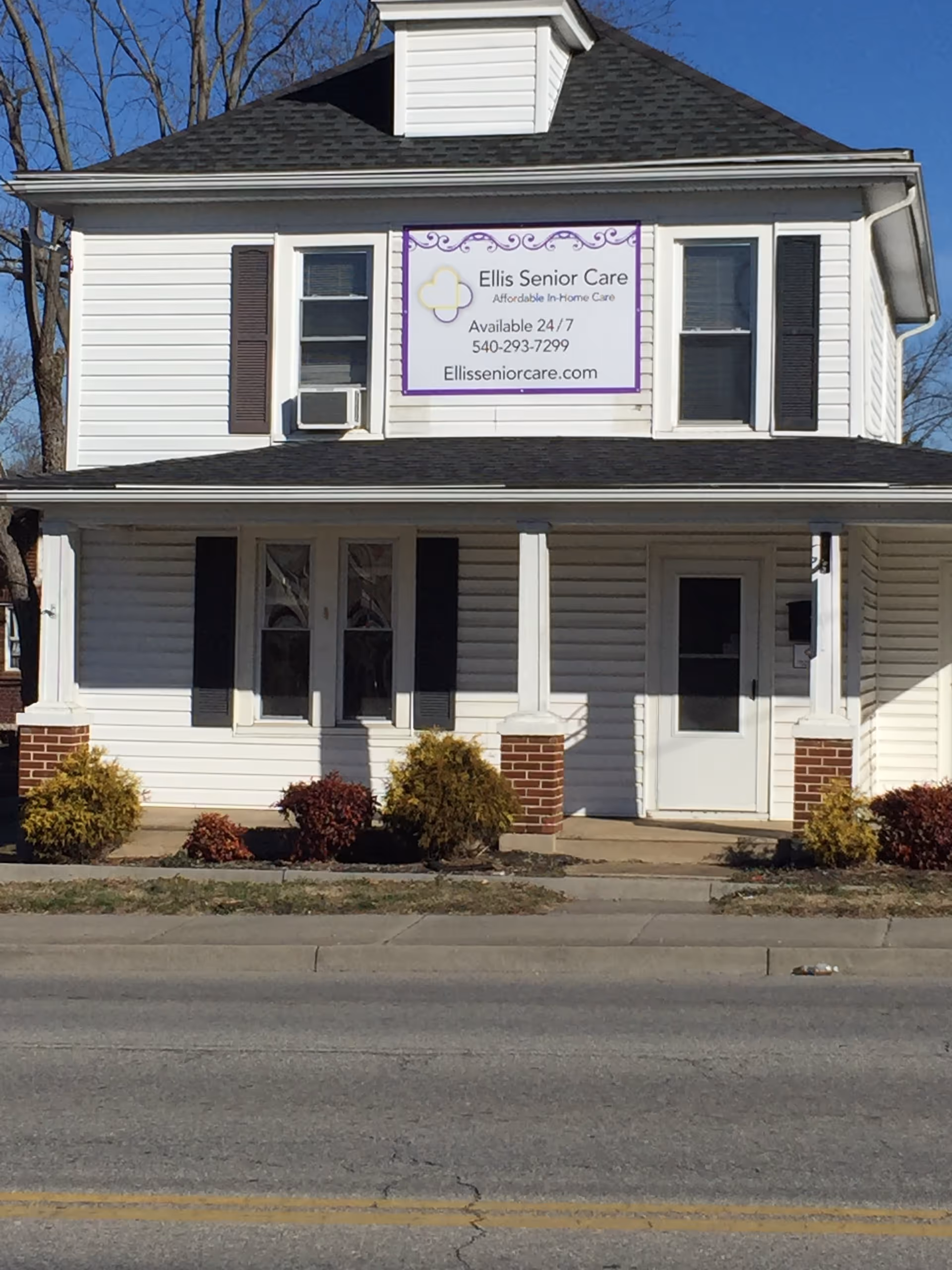 White two-story building with a banner sign for Ellis Senior Care.