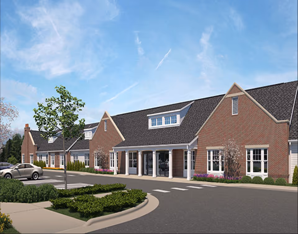 Brick Legacy Ridge senior living facility exterior with circular driveway, landscaping, and glass entry doors.