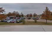 Exterior view of Cypress Point Nursing & Rehabilitation Center with parking lot and trees.