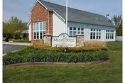 Exterior view of Sunnyside Assisted Living facility with manicured lawn and sign.