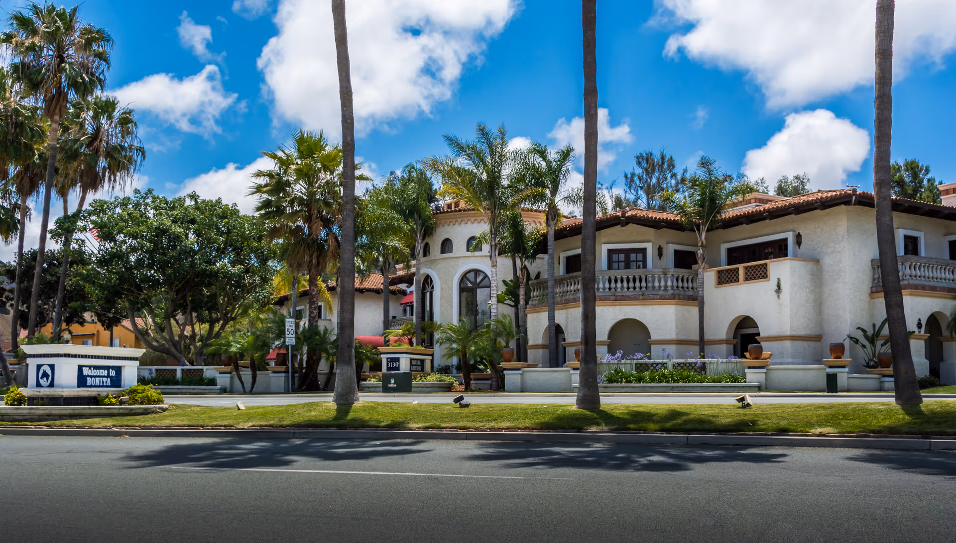 Exterior view of Modern Home Health Care, Inc. building with arches, palm trees, and manicured landscaping.