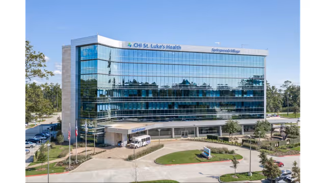 Modern glass-front medical clinic with landscaped entrance in Springwoods Village.