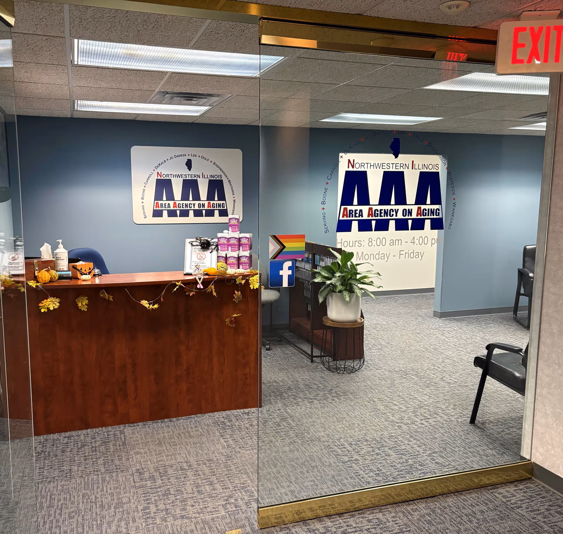 Interior reception area with Northwestern Illinois Area Agency on Aging signage and a wooden desk.