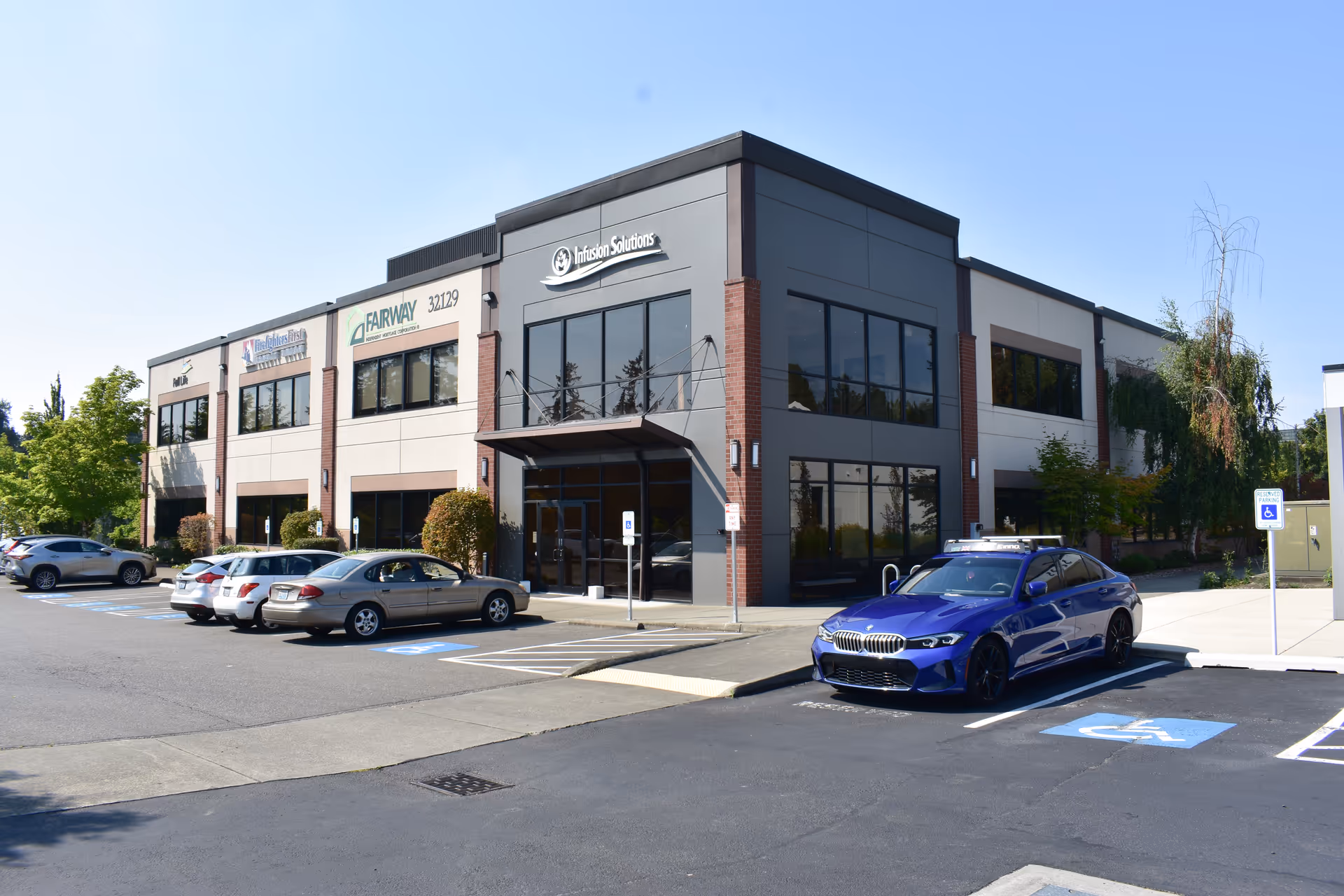 Infusion Solutions building with glass entry and surrounding parking lot.