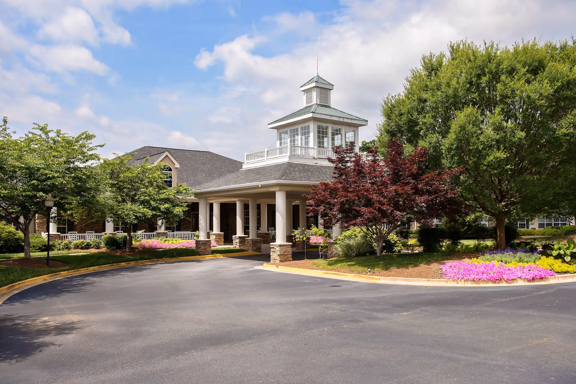 Exterior view of Azalea Estates of Fayetteville with a circular driveway and landscaped entrance.