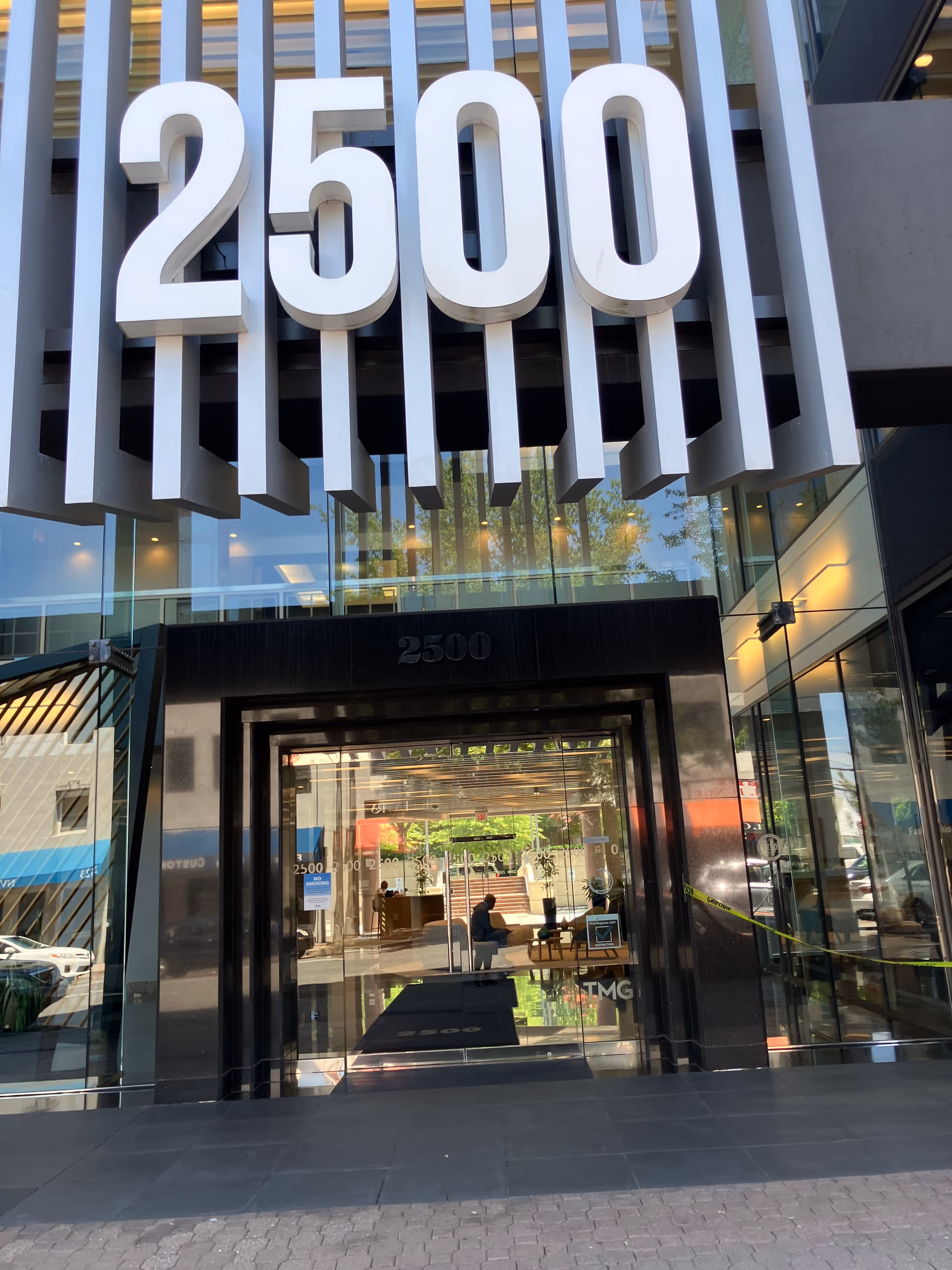 Modern glass-front building entrance with a large 2500 sign above the doorway.