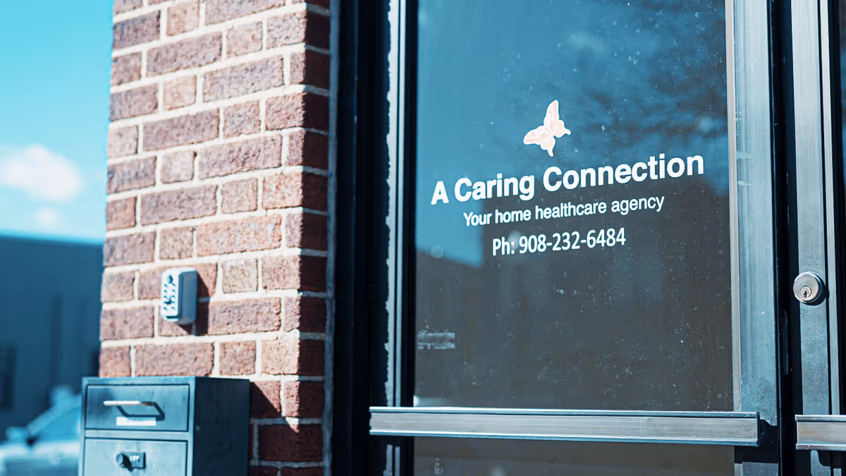 Brick exterior with glass door displaying 'A Caring Connection' and contact information.
