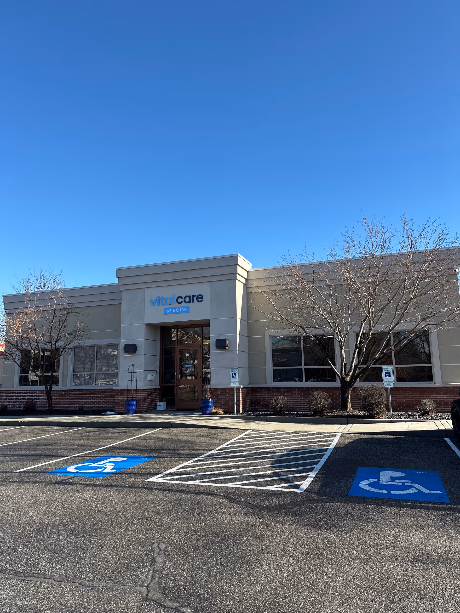 Front view of Vital Care Infusion Services building with handicap parking in lot.