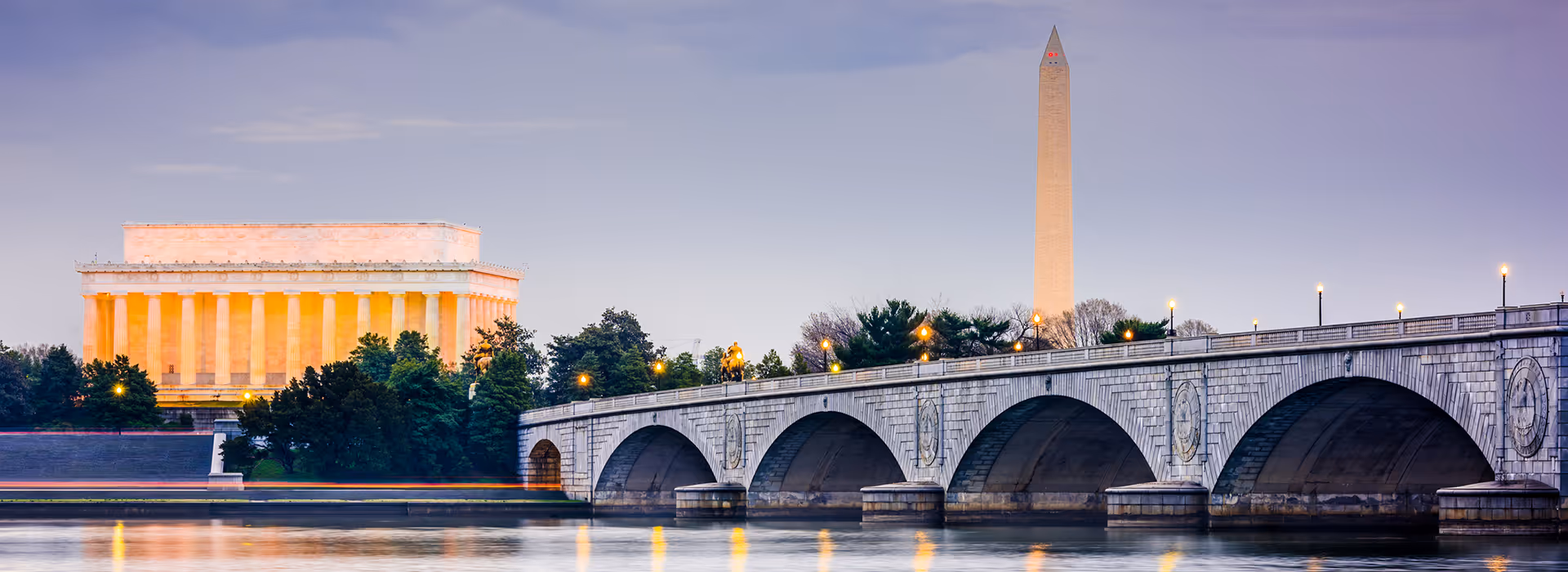 Distant view of DC landmarks Lincoln Memorial and Washington Monument across a river.